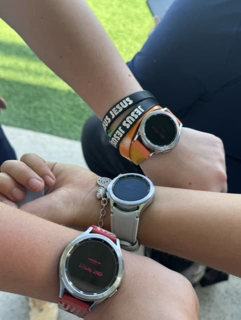 Locked in Girls Showing off watches on game day.jpg